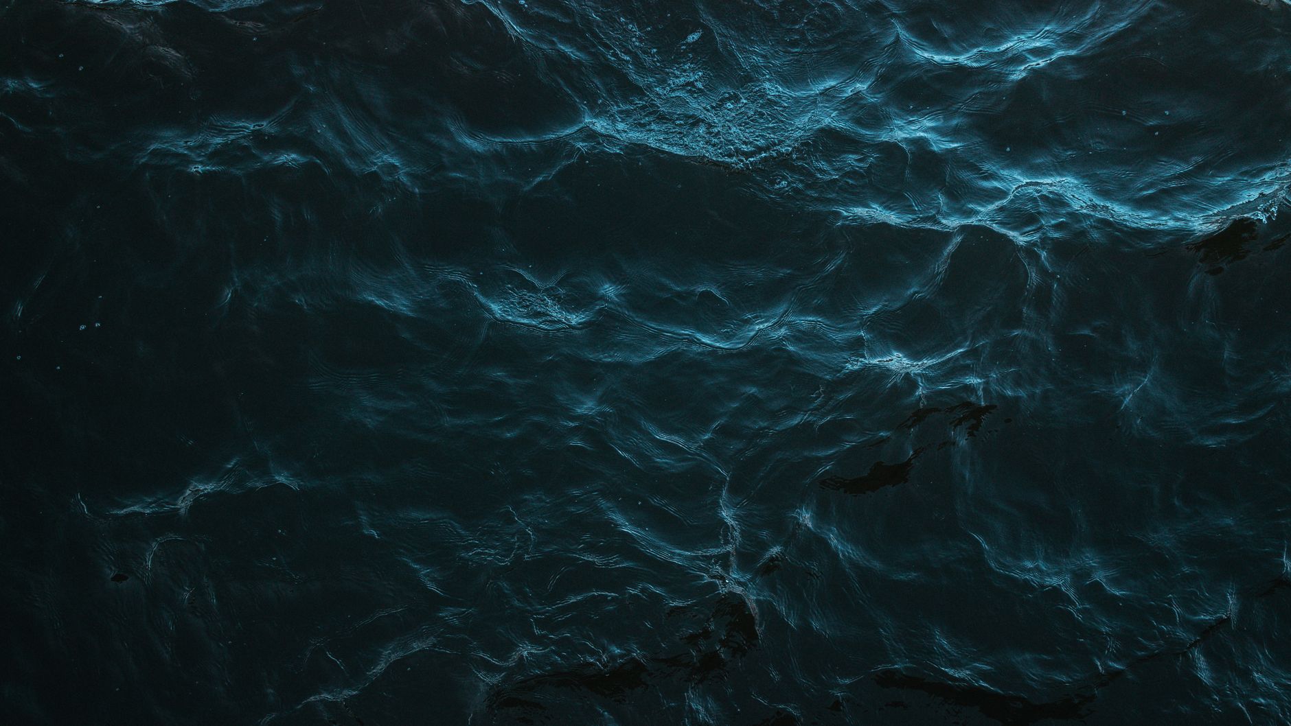Dark ocean surface in fading light with small waves